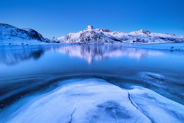 Wall Mural - Mountain ridge and reflection on the lake surface. Natural landscape on the Lofoten islands, Norway. Water and mountains.