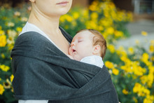 Mother Carrying Sleeping Baby In Sling, Attachment Parenting Concept