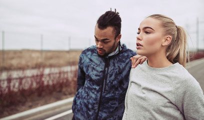 Young couple stretching before jogging along a country road