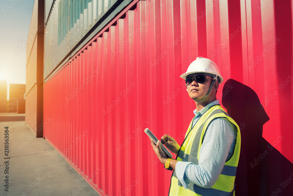Foreman control loading Containers box from Cargo freight ship