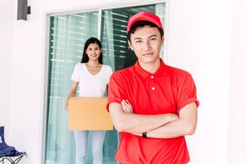 Wall Mural - Woman accepting a delivery boxes from delivery man in red uniform.courier service concept