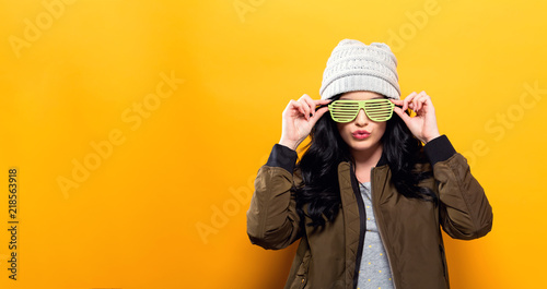 Fotografía Fashionable woman with attitude in bomber jacket on a golden yellow background