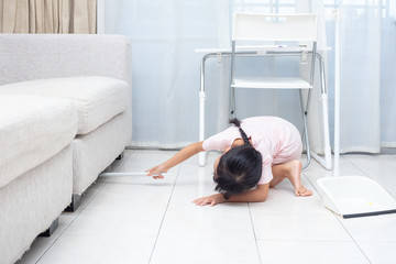 Asian Chinese little girl helping doing cleaning with broom and dustpan