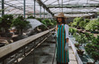 © oneinchpunch - Bonsai greenhouse center. rows with small trees, woman working and taking care of the plants