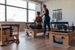 © Jacob Lund - Trainer guiding a pilates woman for correct posture at the gym