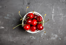 Fresh Ripe Cherries In Small White Ceramic Bowl On The Rustic Background. Selective Focus. 