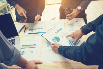 Business people pointing graph sheets on table during discussion of strategy.