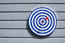Blue Dartboard And Red Dart. Dart Is In The Middle Of The Table, The Bull's Eye.