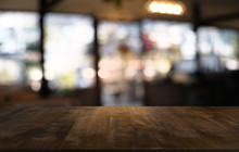 Empty Dark Wooden Table In Front Of Abstract Blurred Bokeh Background Of Restaurant . Can Be Used For Display Or Montage Your Products.Mock Up For Space.