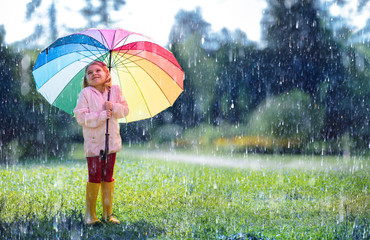 Wall Mural - happy child with rainbow umbrella under rain