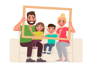 Wall Mural - Family portrait. Dad, mom, son and daughter sitting on the couch, holding a picture frame