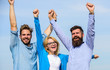 © be free - Company of three happy colleagues or partners celebrating success, sky background. Success concept. Men with beard in formal shirts and blonde in eyeglasses as successful team. Company reached top