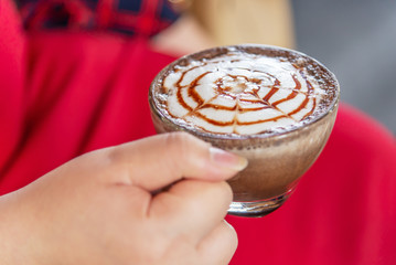 Hand women with cappuccino coffee blurred background