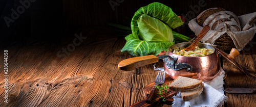 Fotografía young and fresh cabbage cooked with bacon cubes