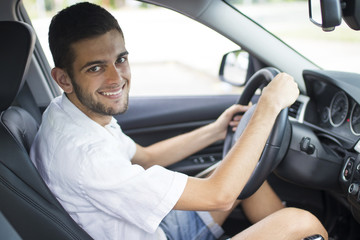 Poster - young adult smiling inside the car driving