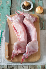 Two carcasses of young rabbits on a wooden board. Rustic style.