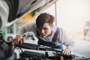 Wall Mural - Young Asian machine technicians are analyzing symptoms of broken car at service center repair