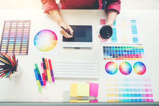 Graphic designer drawing on graphics tablet at workplace