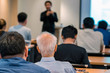© THANANIT - Rear side of Old man Audiences sitting and listening the speackers on the stage in low light meeting room, event and seminar concept
