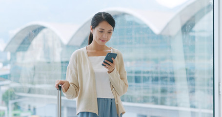 Poster - Woman look at the smart phone in the airport