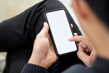Cropped shot of an unrecognizable man using smartphone. Blank screen mobile phone for graphic display montage.