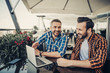 © Yakobchuk Olena - What a joke. Smiling gentlemen sitting at the table with laptop and smartphone