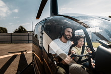 Portrait Of Happy Unshaven Father Embracing Glad Boy While Controlling Helicopter With Him. They Sitting In Cabin Of It While Talking. Optimistic Parent And Guy Wearing Earphones With Microphones