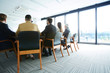 © pressmaster - Backs of delegates sitting on chairs around table during discussion of political questions and points at conference
