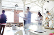 © pressmaster - Blurred motion of young business colleagues working in a busy open plan office