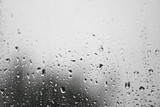 Fototapeta Tęcza - Rainy, autumn weather outside the window. Drops of water on the glass on a blurred background. Romantic grubby topic. Stock photo for design