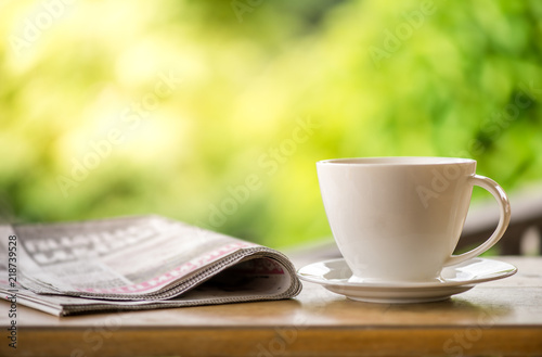 Cuadros en Lienzo good morning coffee cup with news paper on nature green background in garden