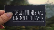 Motivational And Inspirational Quote - ‘Forget The Mistake, Remember The Lesson’ Written On A Black Paper. Vintage Styled Background.