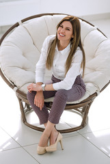 Sticker - confident young woman sitting in a soft round chair