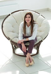 Poster - dreaming young woman sitting in a soft round chair