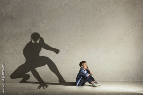 Cuadros en Lienzo The little boy dreaming about hero figure with muscles