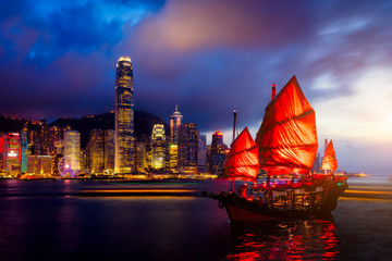 Fototapete - Hong Kong City skyline with tourist sailboat at night. View from across Victoria Harbor Hong Kong.