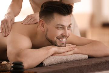 Wall Mural - Young man receiving massage at spa salon