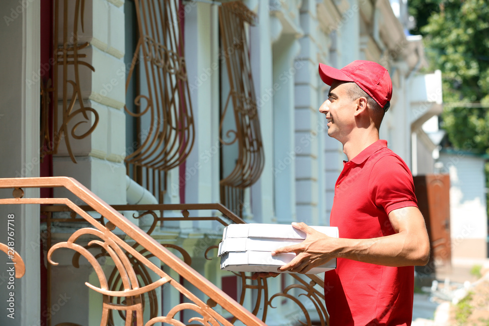 Young man with pizza boxes outdoors. Food delivery service