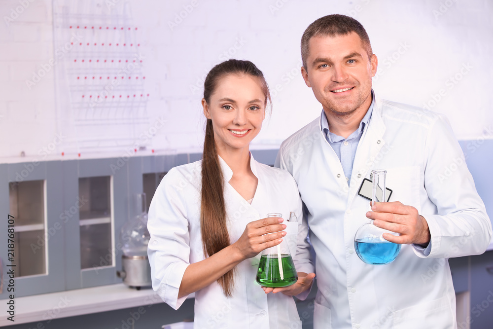 Scientists holding test flasks with samples in laboratory