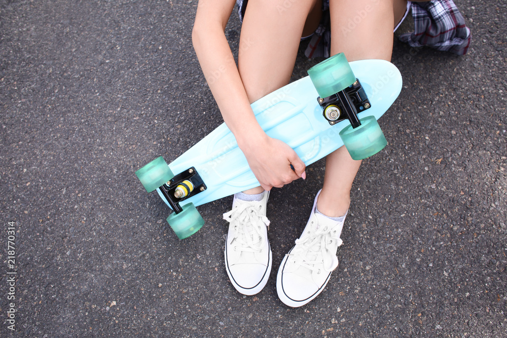 Hipster girl with skateboard outdoors
