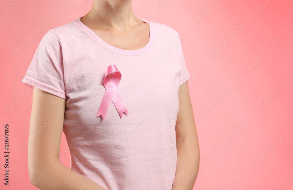 Woman with pink ribbon on color background. Breast cancer awareness concept