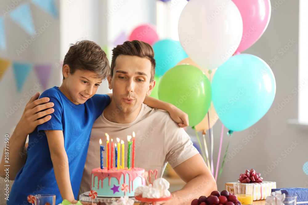 Father and son with birthday cake at party