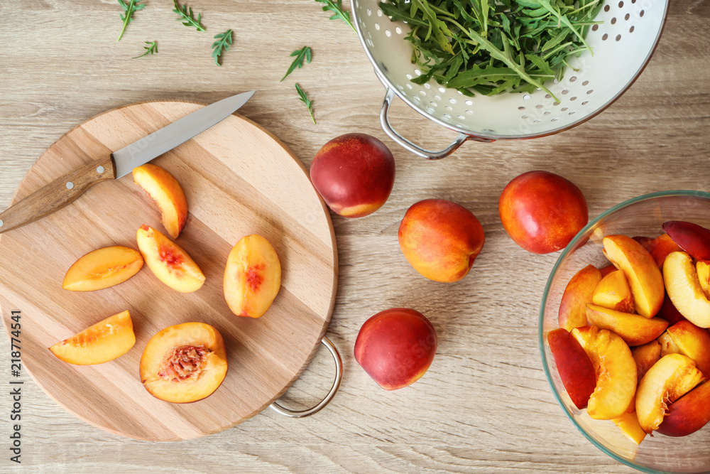 Fresh sliced peaches with wooden board on table