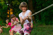 © Svetlana - Group of happy children playing tug of war outside on grass. Kids pulling rope at park. Summer camp fun