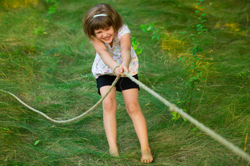 Wall Mural - Sporty girl in tug of war competition in summer vacations