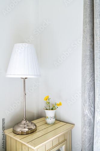 Fotografie, Obraz Closeup of modern nightstand in bedroom, room with side stainless steel lamp, fl