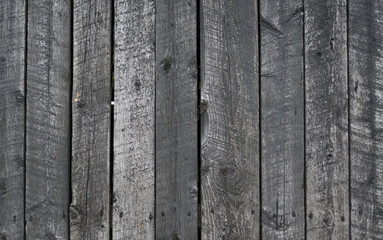 Grungy background of peeling flaking black paint on wooden boards