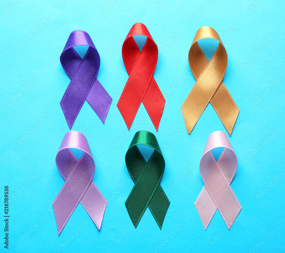 Different ribbons on color background. Cancer concept