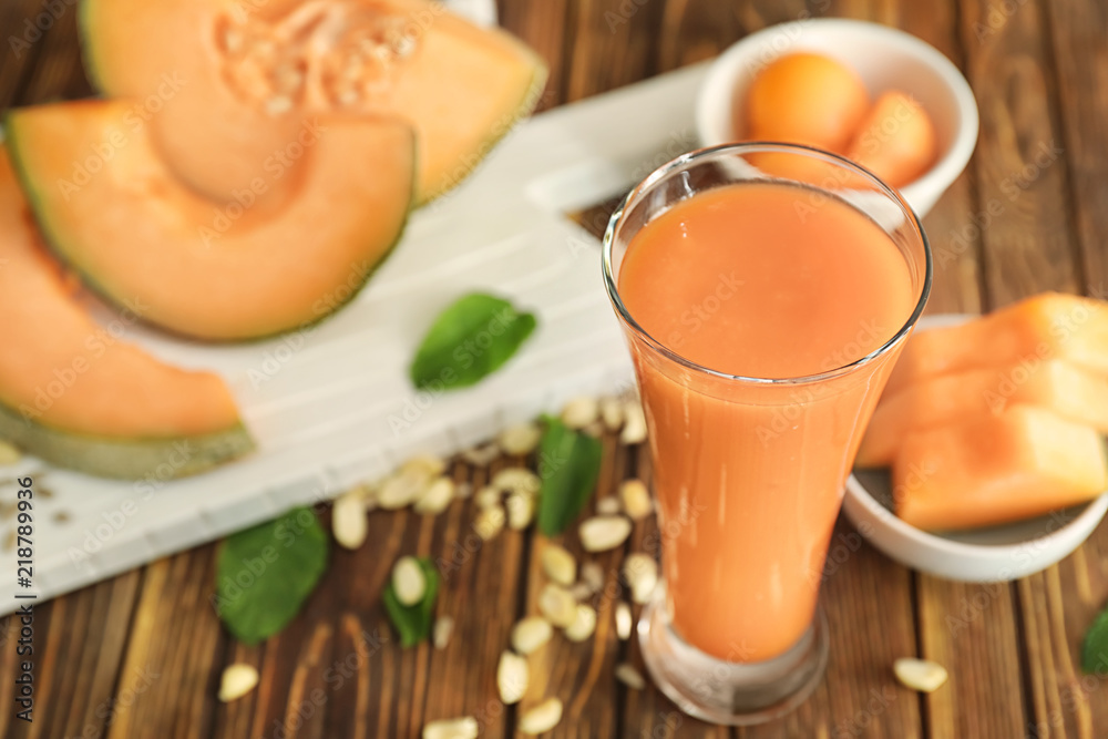 Glass with delicious melon smoothie on wooden table