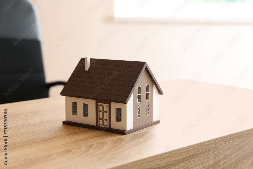 House model on wooden table. Mortgage concept